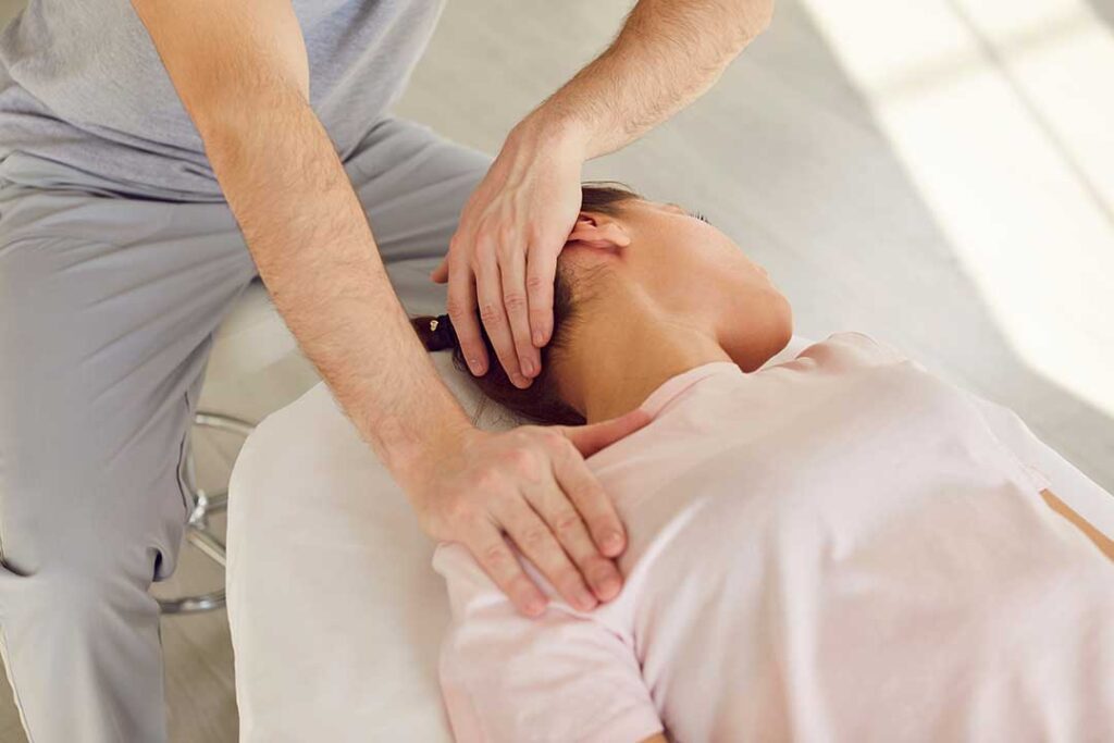 A person gently touching their jaw and neck, indicating mild discomfort or tension.