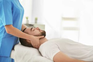 Person sitting calmly while discussing neck tension and anxiety with a healthcare provider in a bright office.