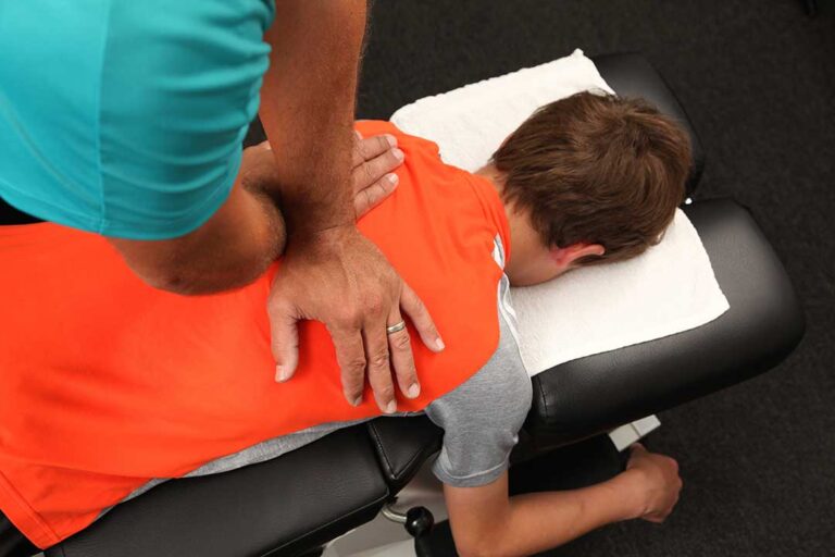 Person using a cold pack on the neck while seated at home after a vehicle accident.